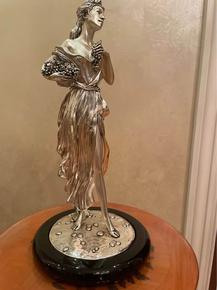 Silver statue of lady with grapes image indicator(2)