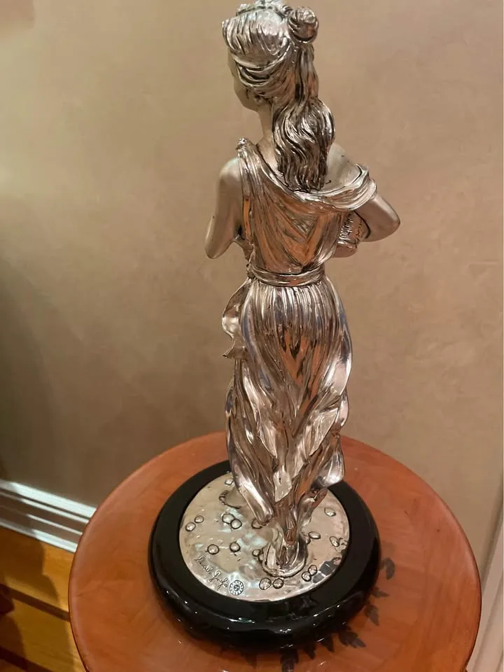 Silver statue of lady with grapes image indicator(4)