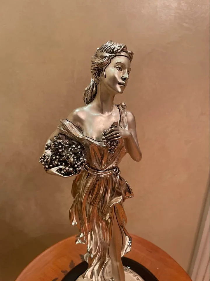 Silver statue of lady with grapes image indicator(5)