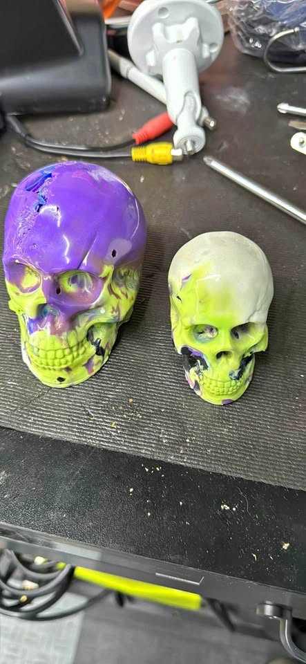 2 colorful skull paperweights
