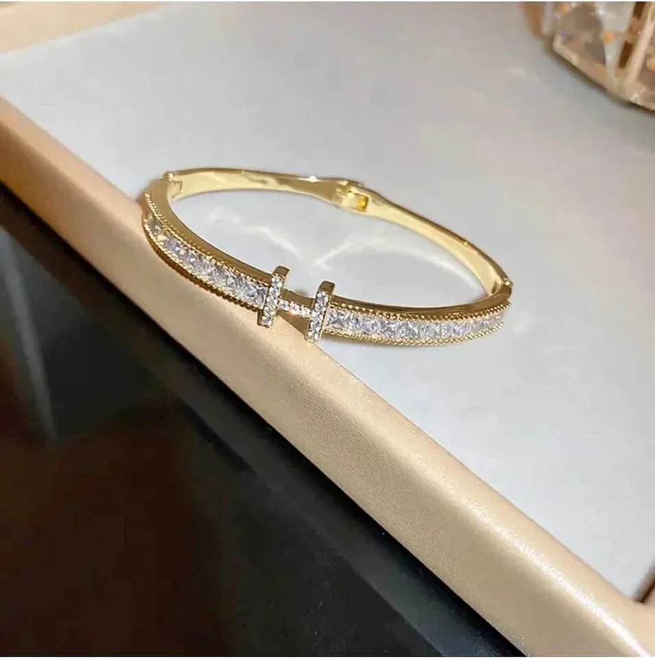 gold-Platted bangle bracelet with a - encrusted "H" initial