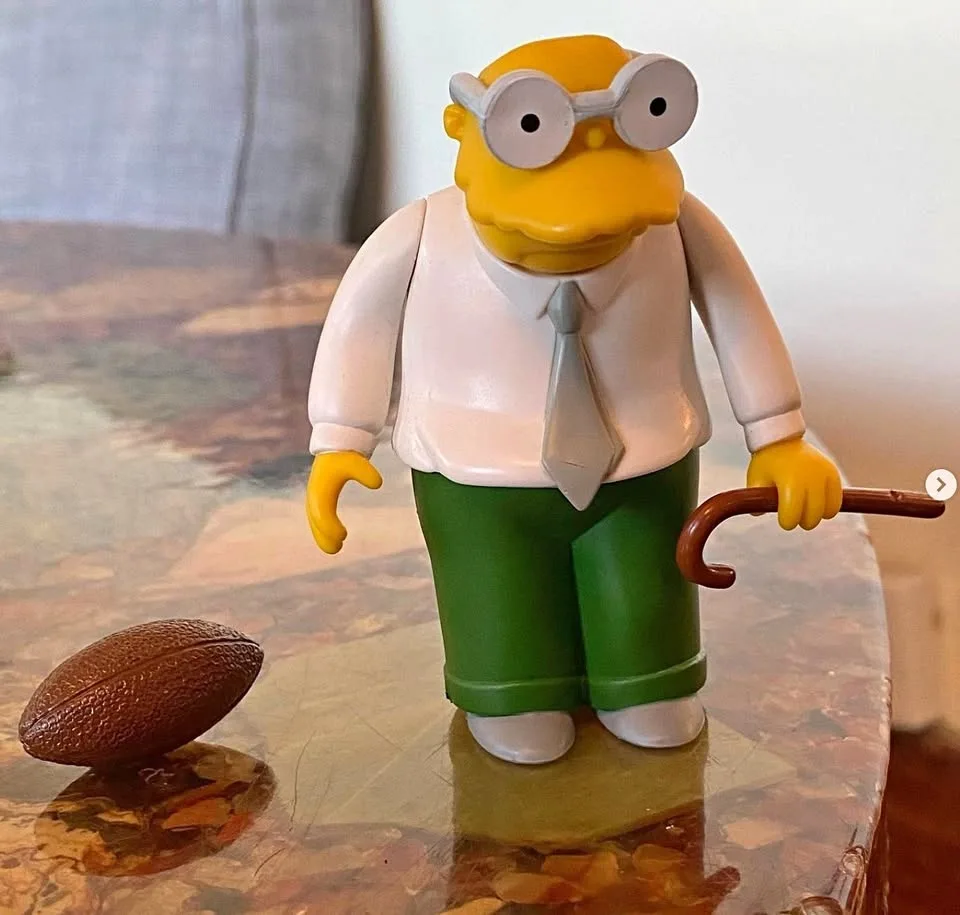 Hans Moleman with football and cane