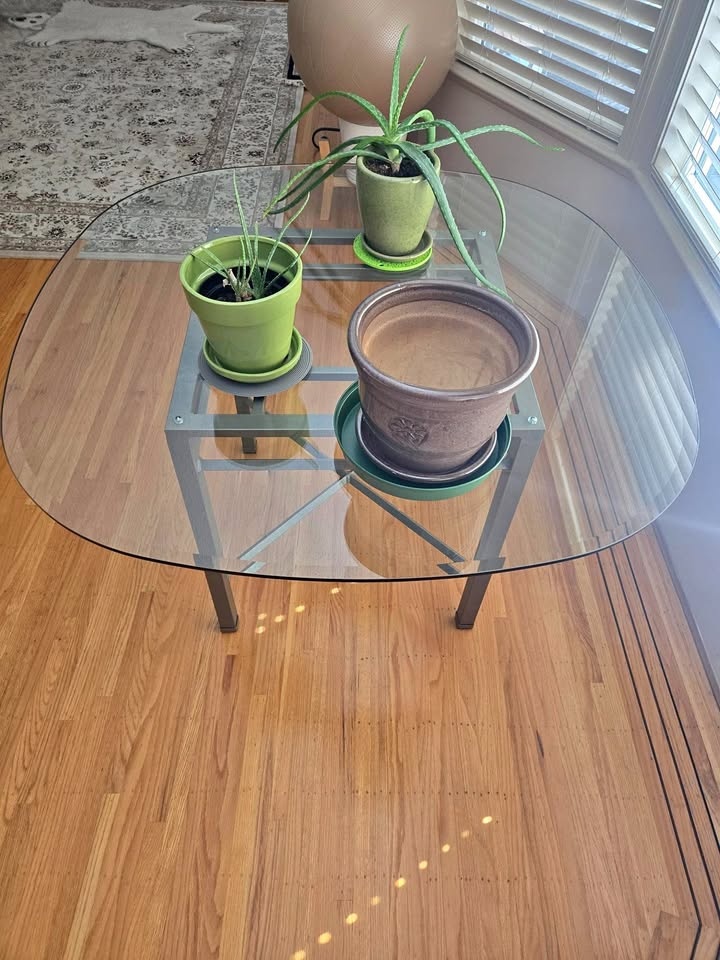 Glass rounded dining table with steel base