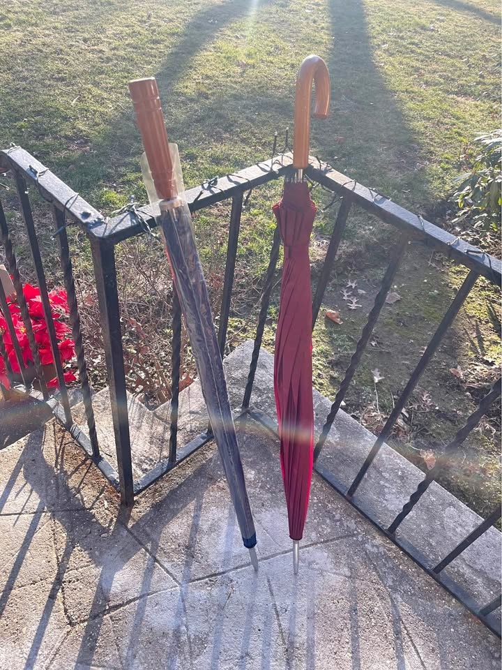 Two oversized umbrellas with wooden handles.