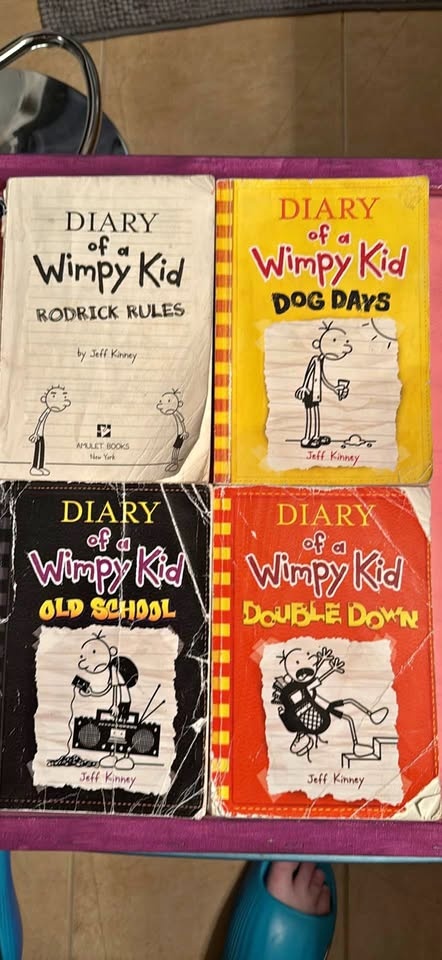 4 well loved paperback diary of a wimpy kid books.