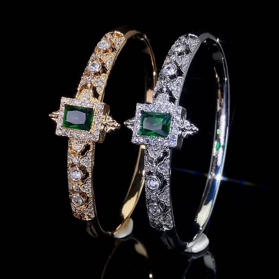 Gold-toned bangle bracelet with a central emerald-cut green zirc - photo 2