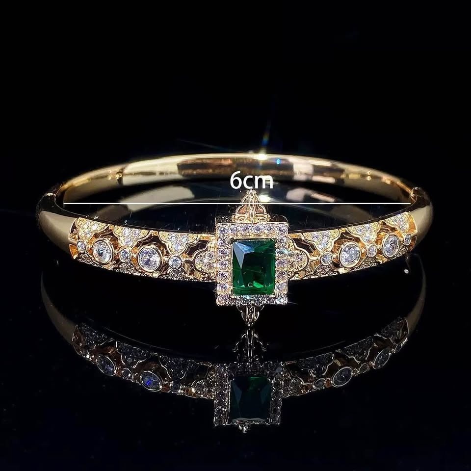 Gold-toned bangle bracelet with a central emerald-cut green zirc - photo 3
