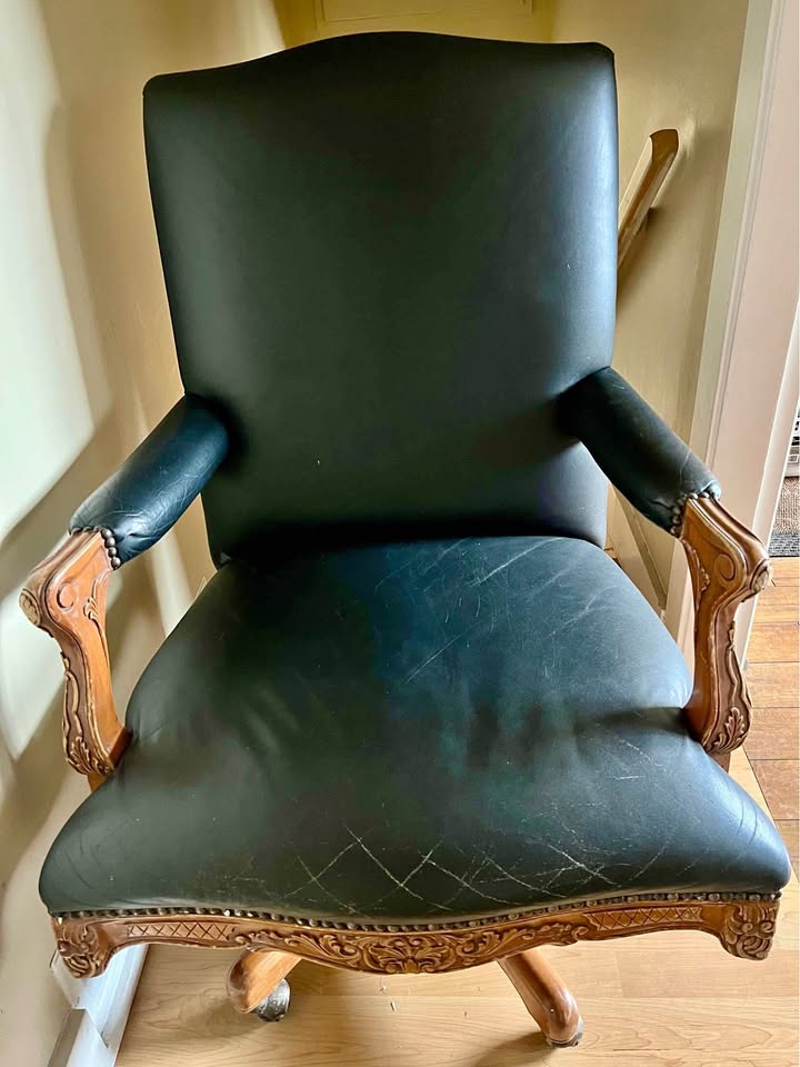 Rustic leather chair with carved wood accents