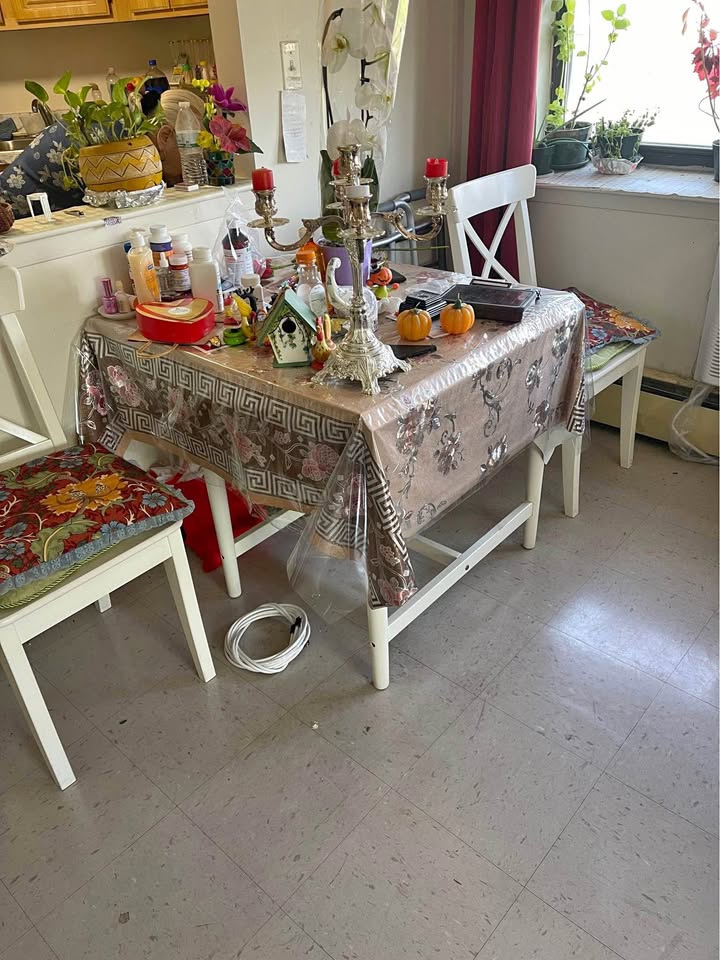 Small dining table with two chairs, white in color