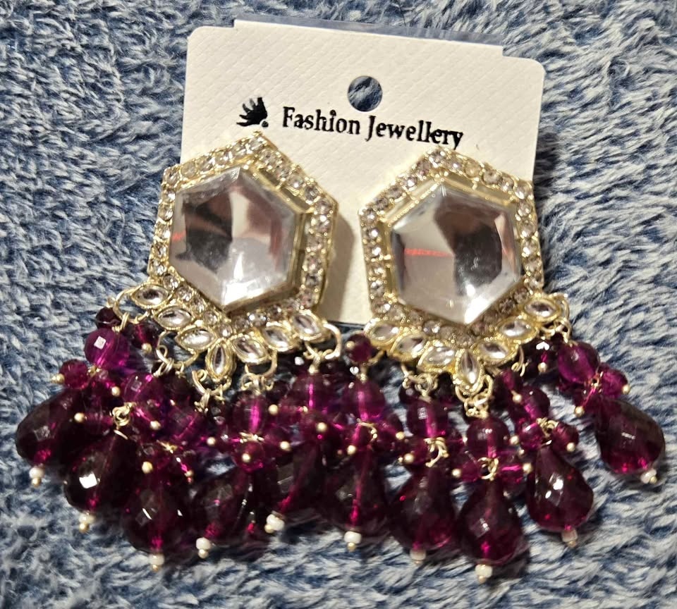 Gold tone dangle earrings with purple beads and clear stones