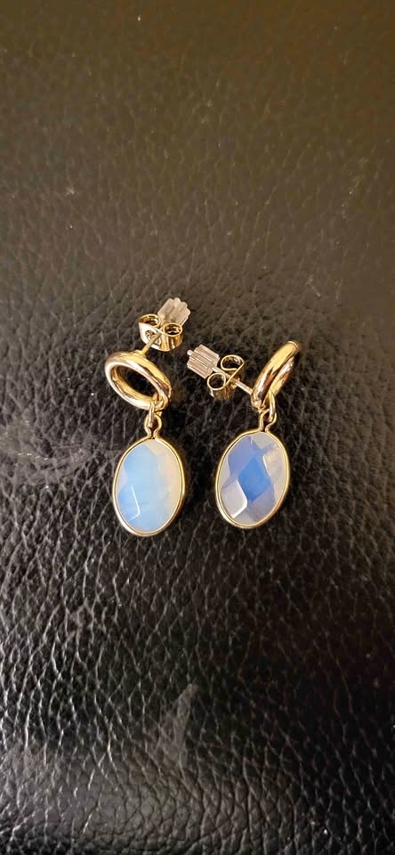 Gold tone dangle earrings with pretty blue oval stones