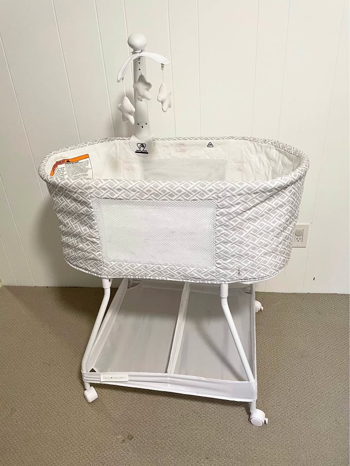 Baby bassinet with cute star mobile that spins, lights up and pl
