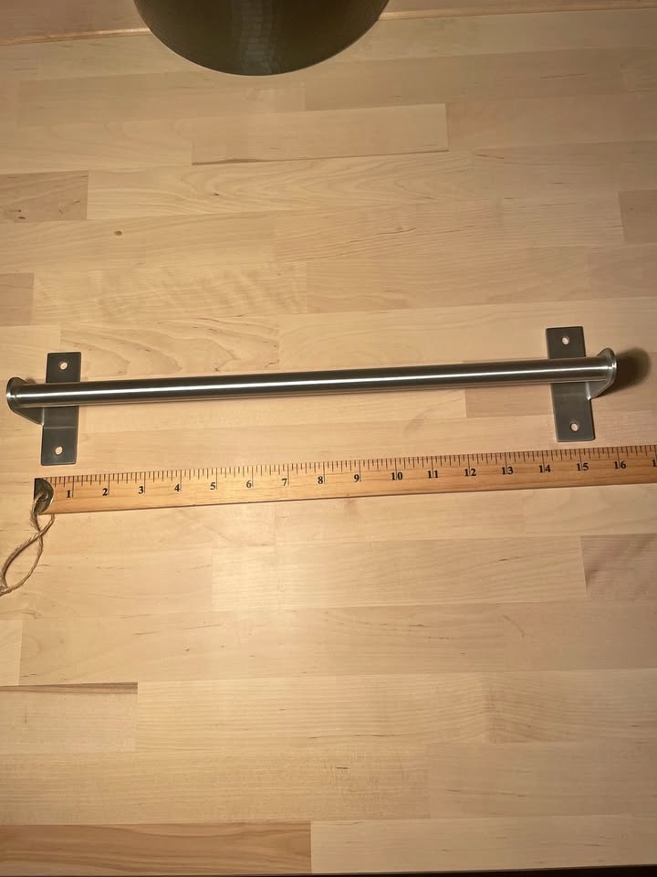 Stainless steel wall-mounted towel bar.