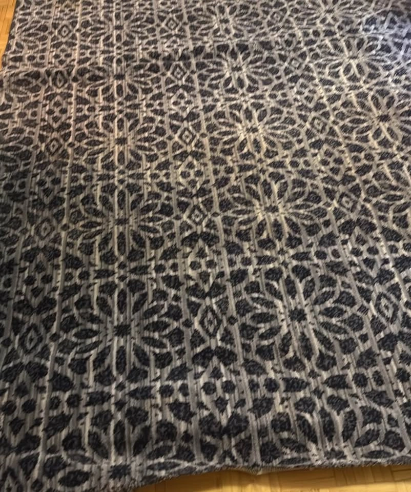Textured area rug with bold woven pattern in deep navy and soft