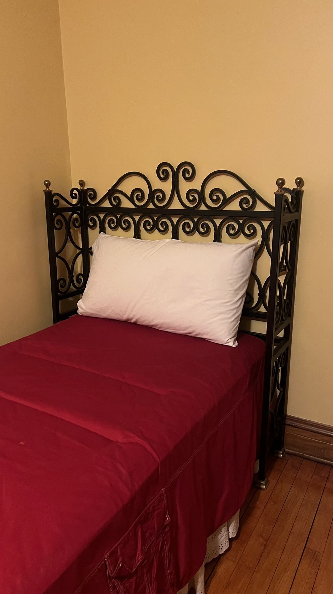 Two single beds with wrought iron headboards and mattresses
