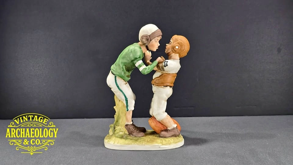 PORCELAIN FIGURINE DEPICTING TWO YOUNG FOOTBALL PLAYERS