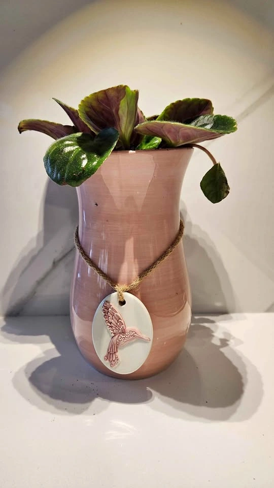 Pink vase hummingbird planter with violet plant