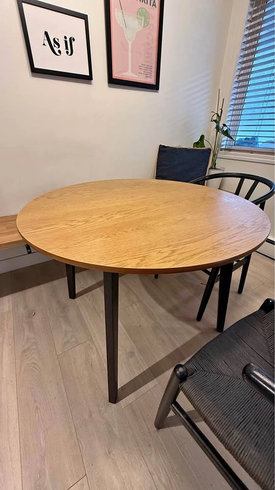Round wood dining table with black legs