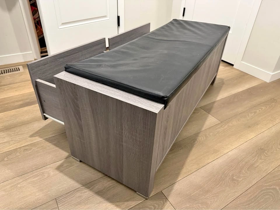 Gray storage bench with drawers and black cushion