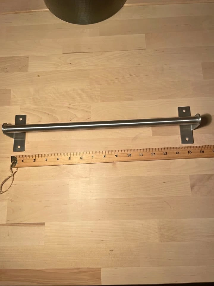 Stainless steel wall-mounted towel bar.