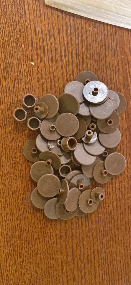 Brown plastic screw covers many pieces