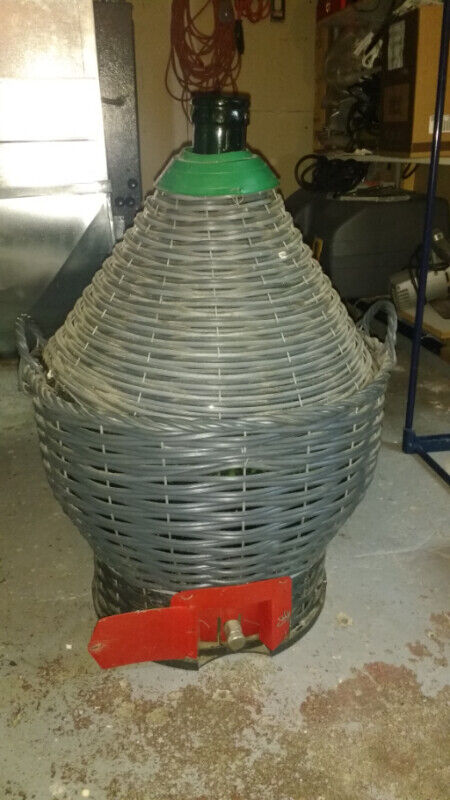 Vintage green glass demi john in basket with spigot