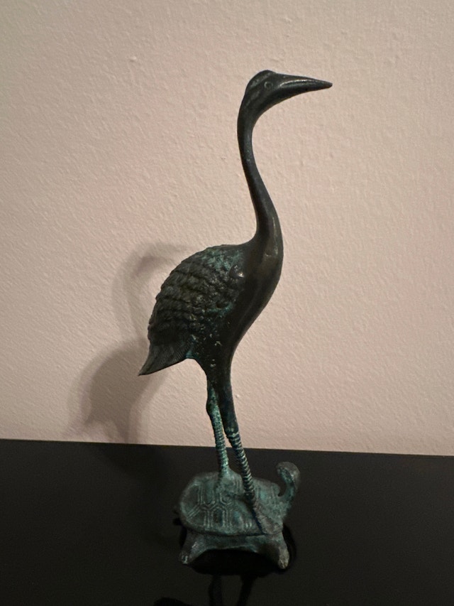 Vintage bronze crane standing on a turtle sculpture