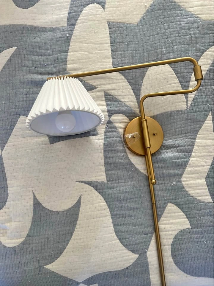 Pair of brass swing arm wall sconces with pleated white shades
