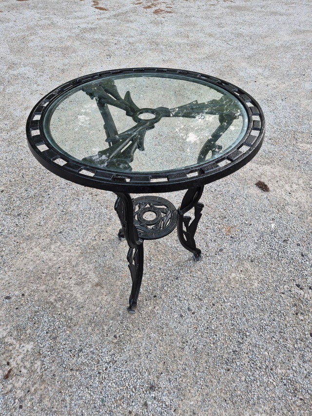Black circle table cast aluminum top, cast iron legs, glass