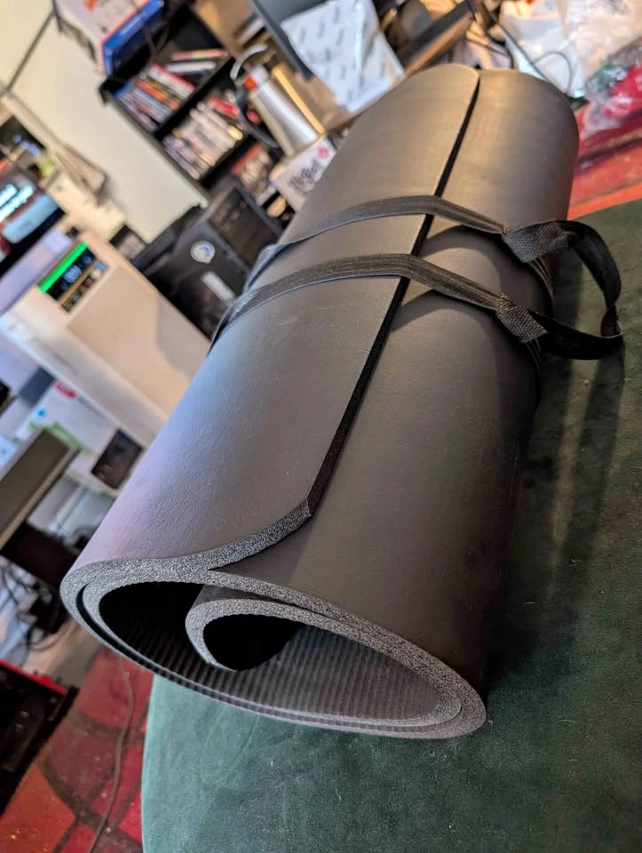 Black yoga mat with carrying strap