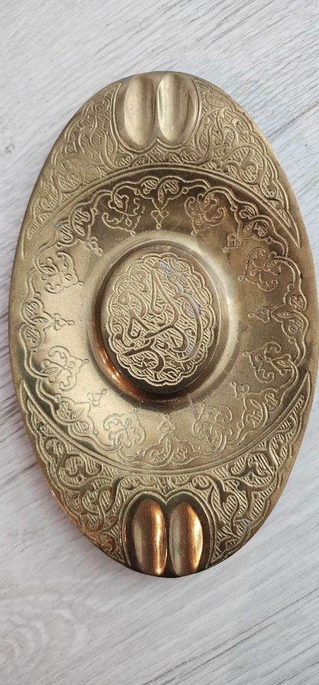 Ornate brass oval ashtray with Arabic calligraphy and floral mot
