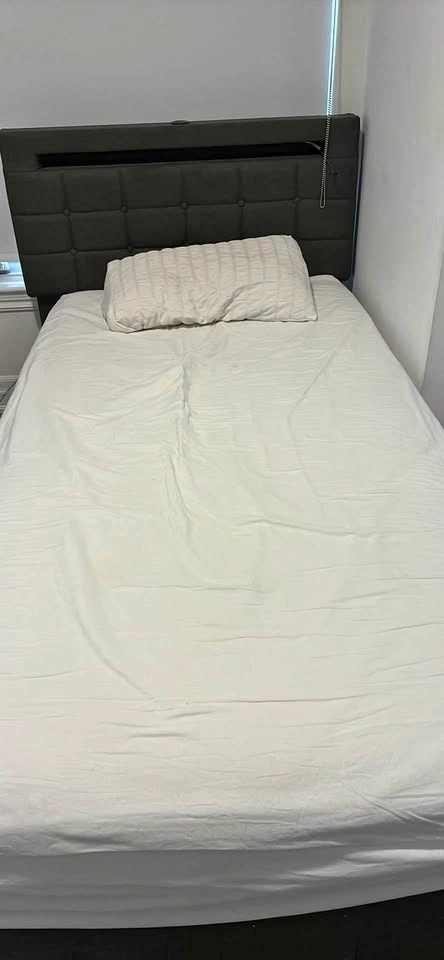 Twin sized bed frame with sheets and pillow