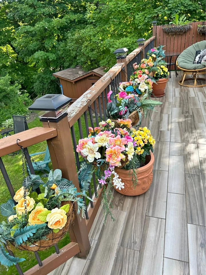 Nine hanging metal planters with silk flowers and plants