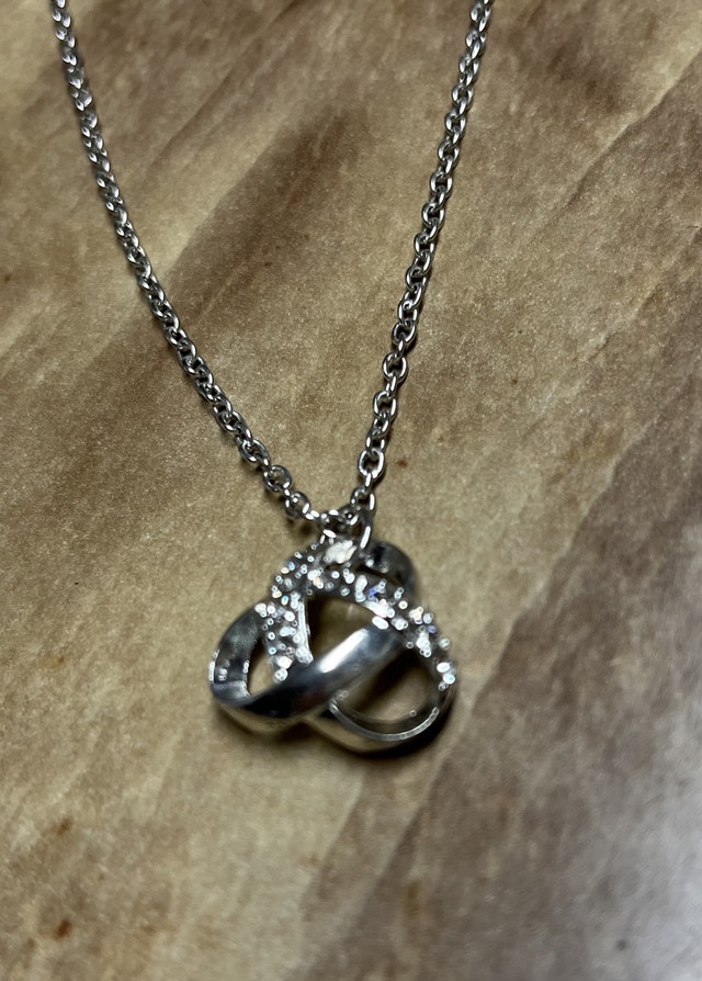 Necklace with interlocking heart pendant. Silver colour