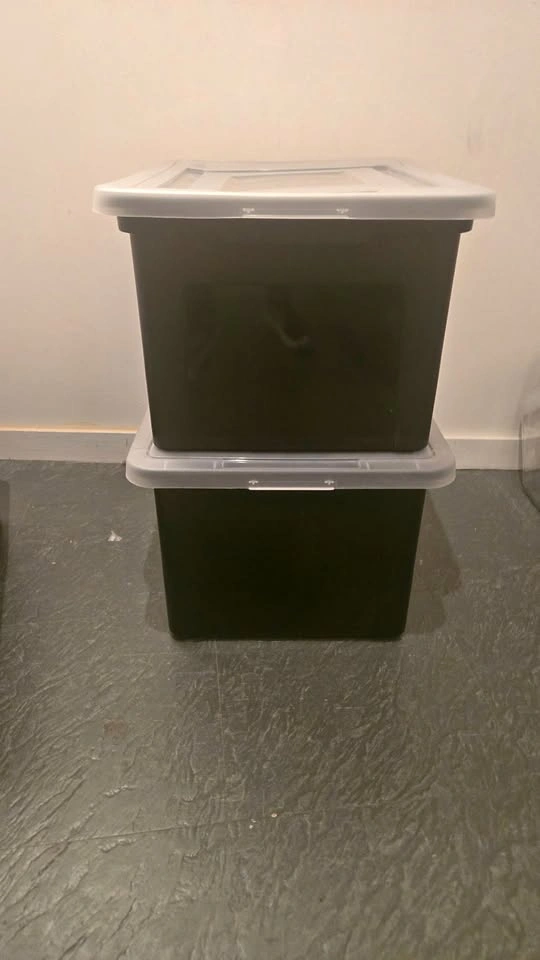 two black plastic bins with clear lids