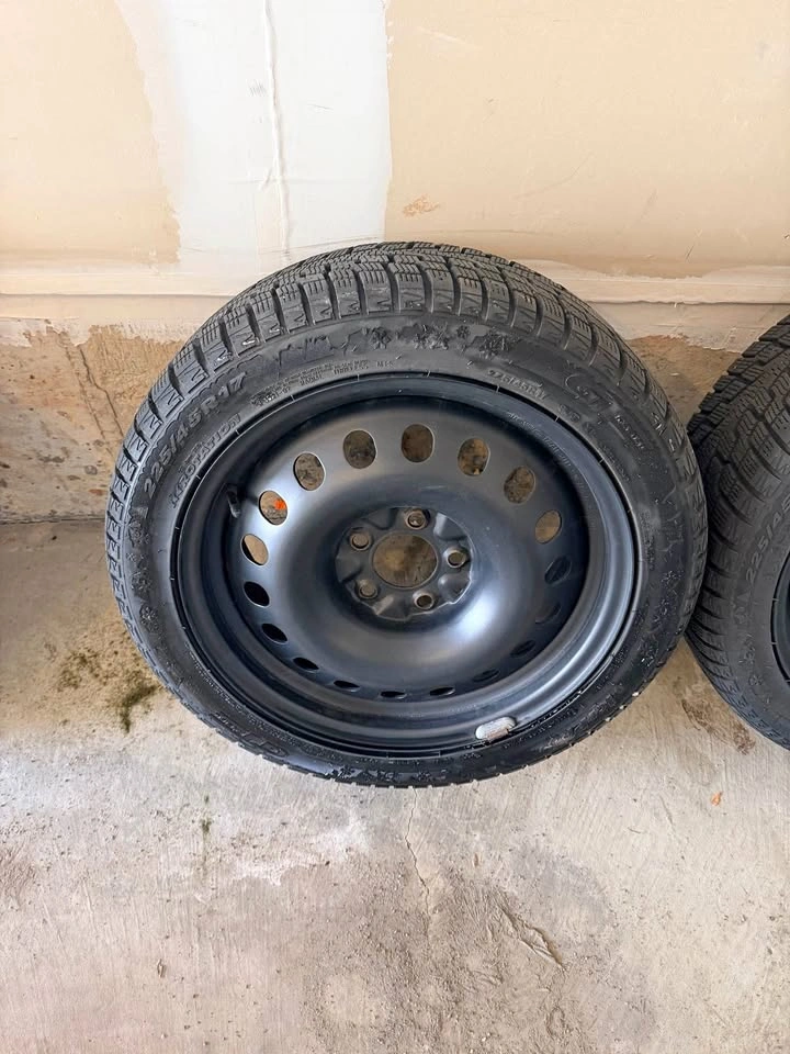 winter tire mounted on black steel rims, size 225/45R17.