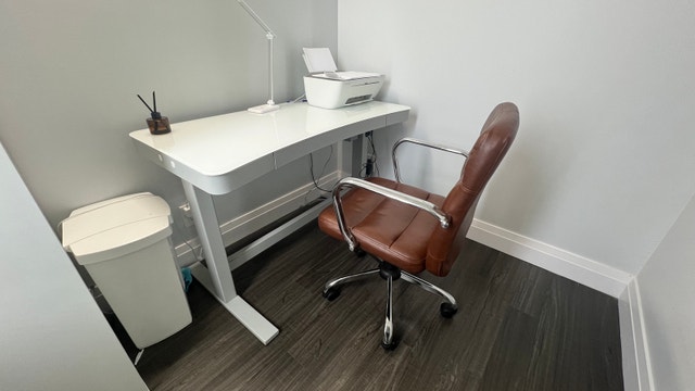 height-adjustable glass-top desk with chair