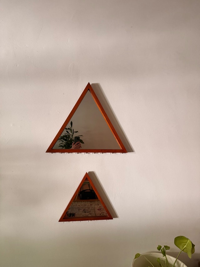 Two triangular mirrors with wooden frames