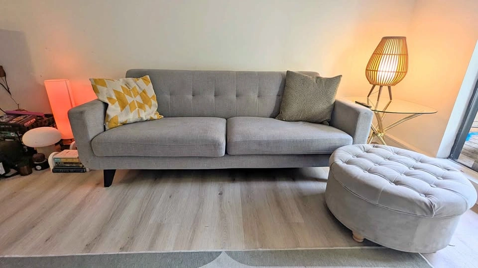 Grey two-seater sofa with storage ottoman