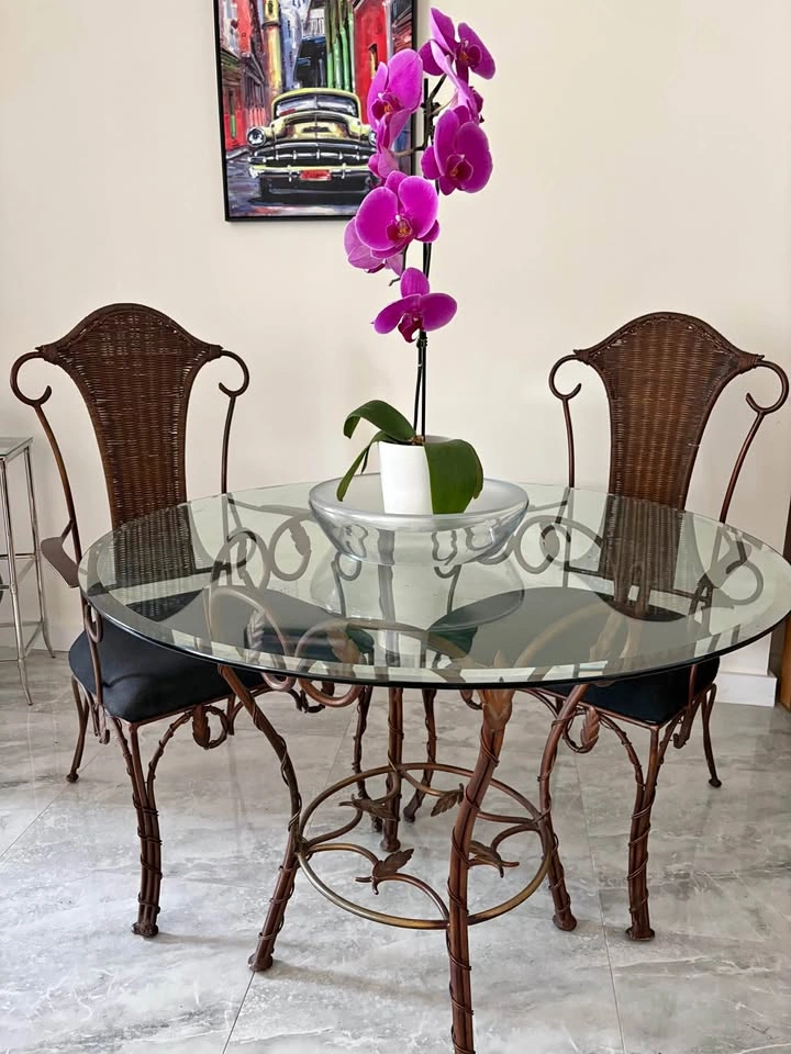 Wrought iron round glass topped table and 2 chairs