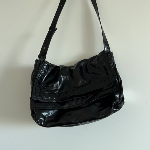 black Zara shoulder bag with a shiny finish and adjustable strap