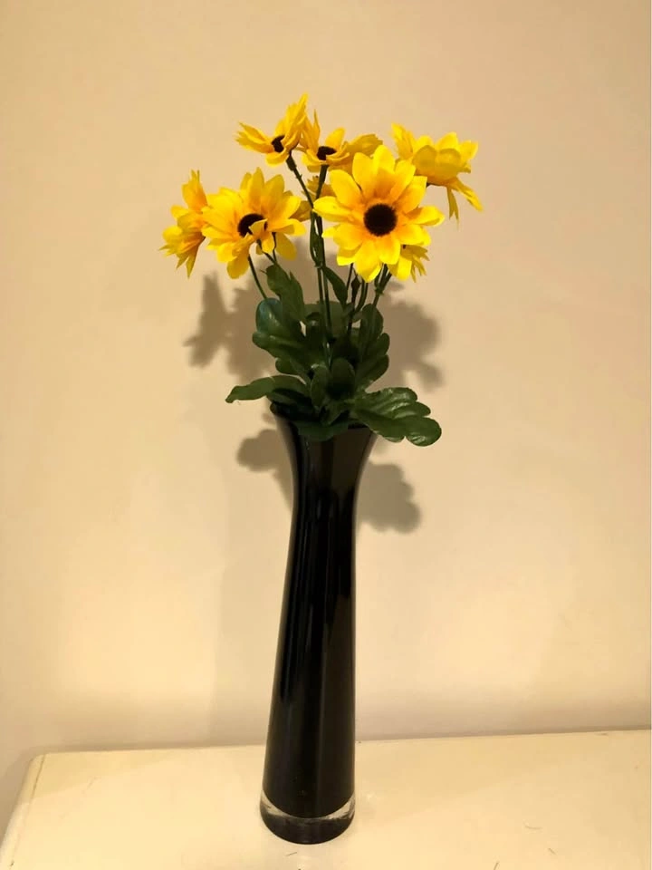 Sunny flower arrangement with dark glass vase