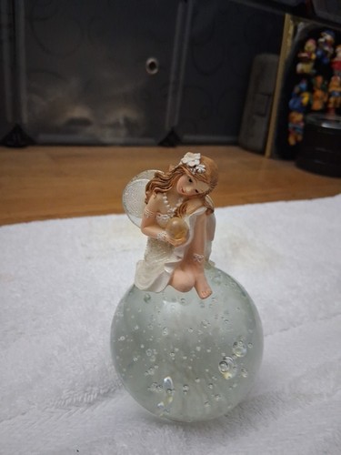 Fairy Figurine Sitting On A Heavy Bubble Glass Sphere