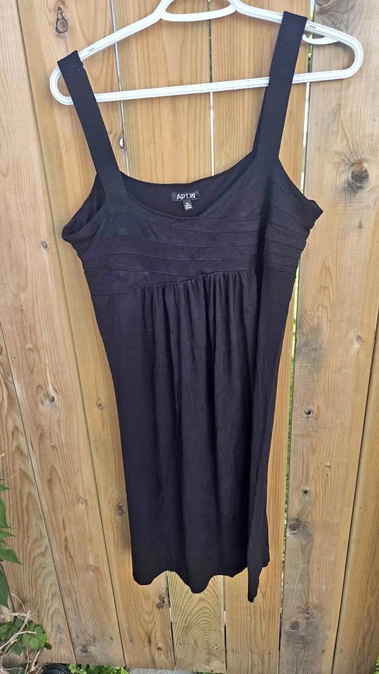 black babydoll mini dress features a smocked bodice and thick st