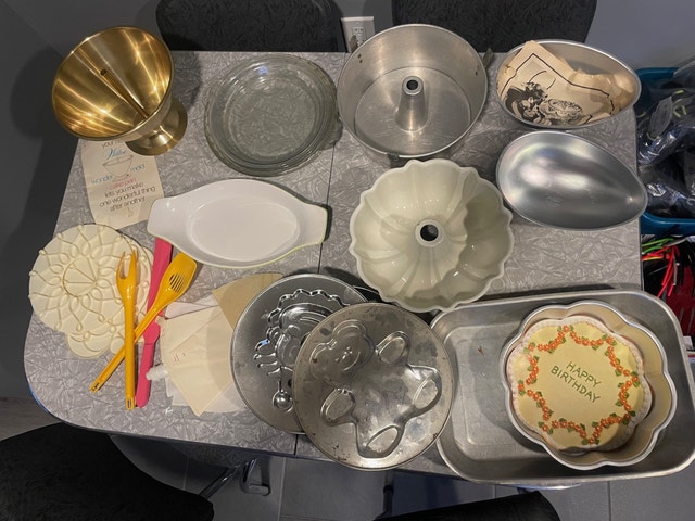 A bunch of baking pans, decorating supplies and pie plates