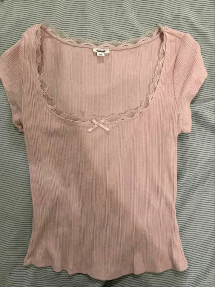 Pink t shirt garage with lace and a bow