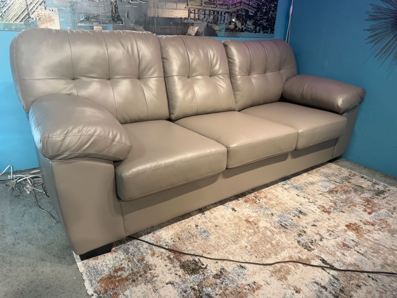 three-seater sofa upholstered in gray leather