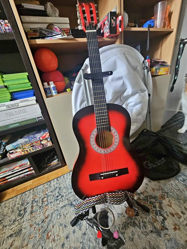 Acoustic guitar with strap, picks, decals, and strings