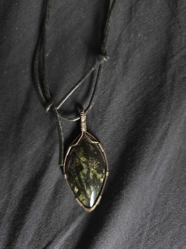 Green agate pendant in wired setting with leather cord