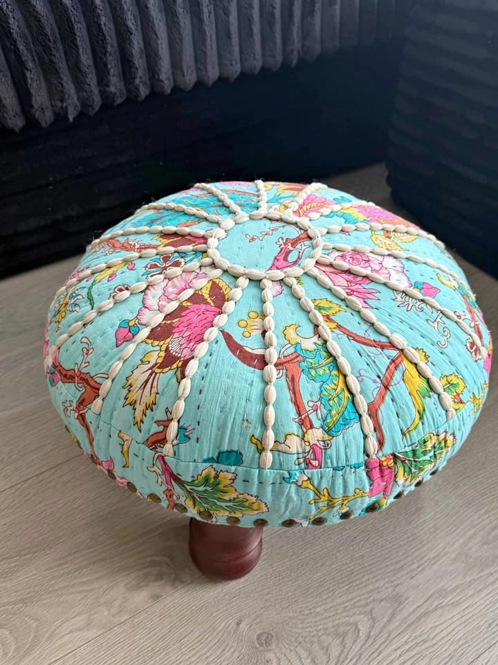 Small round upholstered footstool or ottoman